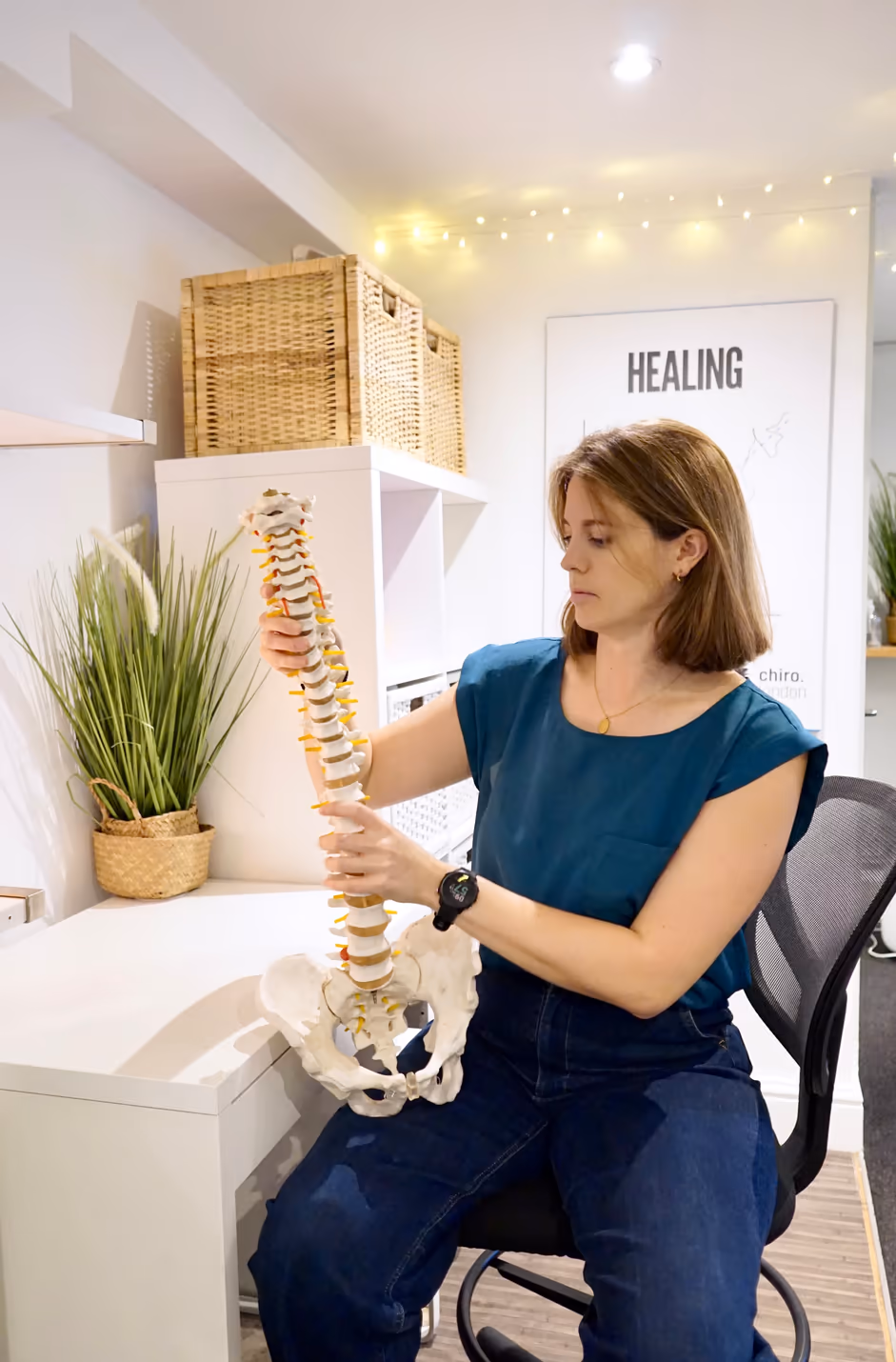 Chiropractor holding an anatomical spine model in a Chiro London consultation room
