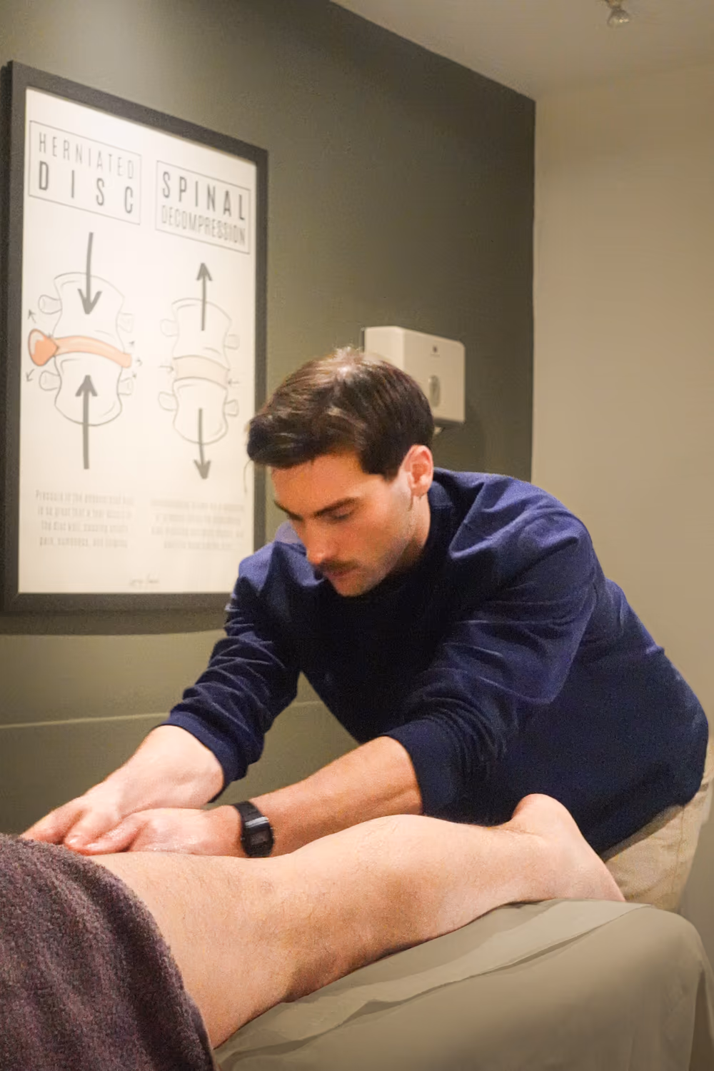 Sports massage therapist treating a patient’s lower leg at a Chiro London clinic